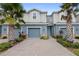 Two-story townhome with gray siding and blue garage doors at 1820 Holden Ridge Ln, Clermont, FL 34715