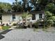 Tan house with a wooden deck, tropical plants, and gravel landscaping at 1117 E Hubbard Ave, Deland, FL 32724
