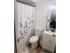 Clean and modern bathroom with white vanity, toilet, and a decorative shower curtain at 2677 Tansboro Dr, Deltona, FL 32725