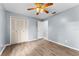 Bedroom with wood-look flooring, a ceiling fan and double doors to closet at 108 Clear Lake Cir, Sanford, FL 32773