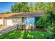 Tan and light blue house with attached garage, well-manicured lawn, and lush landscaping at 108 Clear Lake Cir, Sanford, FL 32773
