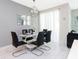 Elegant dining room with glass table, black chairs, and modern chandelier at 4804 Romeo Cir, Kissimmee, FL 34746