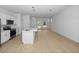 Open floor plan connecting kitchen and living areas with light hardwood floors at 7883 Sw 138Th Street Rd, Ocala, FL 34473