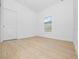 Simple bedroom with light wood flooring and window at 7883 Sw 138Th Street Rd, Ocala, FL 34473