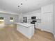 Open concept kitchen and living area with white cabinets and hardwood floors at 7883 Sw 138Th Street Rd, Ocala, FL 34473