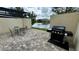 Brick paved patio with seating area and gas grill overlooking a lake at 3167 Tocoa Cir, Kissimmee, FL 34746