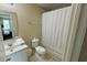 Bathroom with a toilet, sink, bathtub, and shower curtain at 3167 Tocoa Cir, Kissimmee, FL 34746