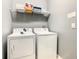 Bright laundry room with washer and dryer, and shelving for storage at 1471 Rolling Fairway Dr, Davenport, FL 33896