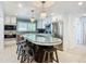 Island kitchen with white cabinets, stainless steel appliances, and blue mosaic backsplash at 2903 Hill St, New Smyrna Beach, FL 32169
