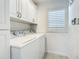 Clean laundry room with white cabinets and matching washer and dryer at 2903 Hill St, New Smyrna Beach, FL 32169
