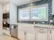 Modern kitchen with white cabinets, stainless steel appliances, and a blue mosaic backsplash at 2903 Hill St, New Smyrna Beach, FL 32169