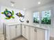 White kitchen cabinets with marble countertops and coastal wall art at 2903 Hill St, New Smyrna Beach, FL 32169