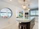 View of kitchen island with marble top and dark wood base, and a circular window to living room at 2903 Hill St, New Smyrna Beach, FL 32169