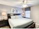 Bedroom with large bed, ceiling fan, dark dresser, and ocean decor at 1410 Wexford Way, Davenport, FL 33896