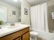 Clean bathroom with a bathtub, toilet and wood vanity at 1410 Wexford Way, Davenport, FL 33896