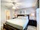 Bedroom with large bed, ceiling fan, dark dresser, and ocean decor at 1410 Wexford Way, Davenport, FL 33896