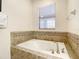 Soaking tub with tile surround and window at 1410 Wexford Way, Davenport, FL 33896