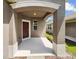 Covered front porch with a burgundy door and arched entryway at 3420 Sagebrush St, Harmony, FL 34773