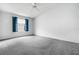 Spacious bedroom with gray carpet and window with blue curtains at 17479 Se 82Nd Pecan Ter, The Villages, FL 32162