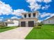 Two-story home with gray siding and paver driveway at 16046 Volterra Pt, Bella Collina, FL 34756