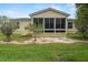 House exterior showcasing a screened porch and landscaping at 17394 Se 74Th Seabrook Ct, The Villages, FL 32162