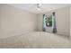 Bright bedroom with carpeted floor and window with teal curtains at 17394 Se 74Th Seabrook Ct, The Villages, FL 32162