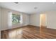 Living room with wood-look floors and access to hallway at 17394 Se 74Th Seabrook Ct, The Villages, FL 32162