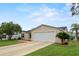 Tan one-story house with two-car garage and landscaping at 17394 Se 74Th Seabrook Ct, The Villages, FL 32162