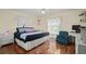 Bedroom with king bed, hardwood floors, and home office area at 2101 Appy Ln, Apopka, FL 32712