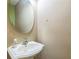 Small bathroom with pedestal sink and oval mirror at 13950 Morning Frost Dr, Orlando, FL 32828