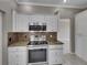 Modern kitchen with stainless steel range and white cabinets at 526 Pinehurst Cv, Kissimmee, FL 34758