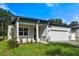 New construction home with gray exterior, white garage door, and landscaping at 2866 Lingo Ln, Orlando, FL 32822
