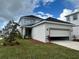 Two-story home with open garage, landscaping, and driveway at 9982 Fiddley Aly, Orlando, FL 32827