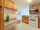 View of kitchen with wood cabinets, granite countertops, and appliances at 1100 Delaney Ave # F203, Orlando, FL 32806