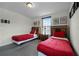 Bedroom with two twin beds, red bedding, and a window with blinds at 1427 Rolling Fairway Dr, Davenport, FL 33896