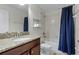 Bathroom with tub shower, granite vanity, and blue shower curtain at 1427 Rolling Fairway Dr, Davenport, FL 33896