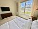 Bedroom with large window, wall art, and a cozy bed at 9095 Sommerset Hills Dr, Davenport, FL 33896
