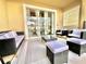 Relaxing patio with wicker furniture, a grill, and sliding glass doors at 9095 Sommerset Hills Dr, Davenport, FL 33896