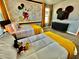 Mickey Mouse themed bedroom with two twin beds and yellow accents at 9095 Sommerset Hills Dr, Davenport, FL 33896