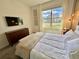 Bedroom with large window, wall art, and a cozy bed at 9095 Sommerset Hills Dr, Davenport, FL 33896