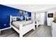 Bright bedroom with two twin beds, blue accent wall, and gray flooring at 8930 Sydney Ave, Kissimmee, FL 34747