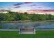 Serene lakeside view with a bench at sunset at 610 Celebration Ave # 1209, Celebration, FL 34747