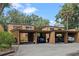 Exterior view of three-unit building with covered parking and mature trees at 245 Crown Oaks Way # 245, Longwood, FL 32779