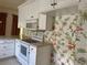 White kitchen with appliances and tropical wallpaper at 2331 Salzburg Loop, Winter Haven, FL 33884