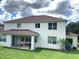 Covered patio, grassy backyard with grill and table at 963 N Jacks Lake Rd, Clermont, FL 34711