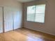 Well-lit bedroom with bamboo flooring and double-door closet at 963 N Jacks Lake Rd, Clermont, FL 34711