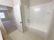 Clean bathroom with a tub, toilet and wood door at 4881 Cypress Woods Dr # 3213, Orlando, FL 32811