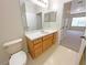 Bathroom with wood vanity, toilet and a mirror at 4881 Cypress Woods Dr # 3213, Orlando, FL 32811