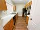 Galley kitchen with wood cabinets and appliances at 4881 Cypress Woods Dr # 3213, Orlando, FL 32811