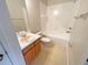 Clean bathroom with a tub, toilet and vanity with wood cabinets at 4881 Cypress Woods Dr # 3213, Orlando, FL 32811